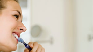 A pregnant women brushing her teeth