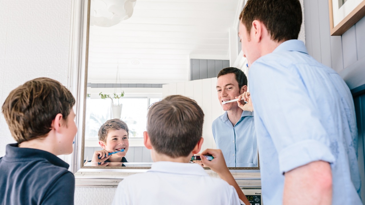Dr. Grant McGrath brushing his teeth, and the kids are brushing their teeth too to help prevent tooth decay