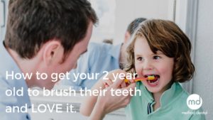 Dr. Grant brushing a child's teeth to prevent tooth decay